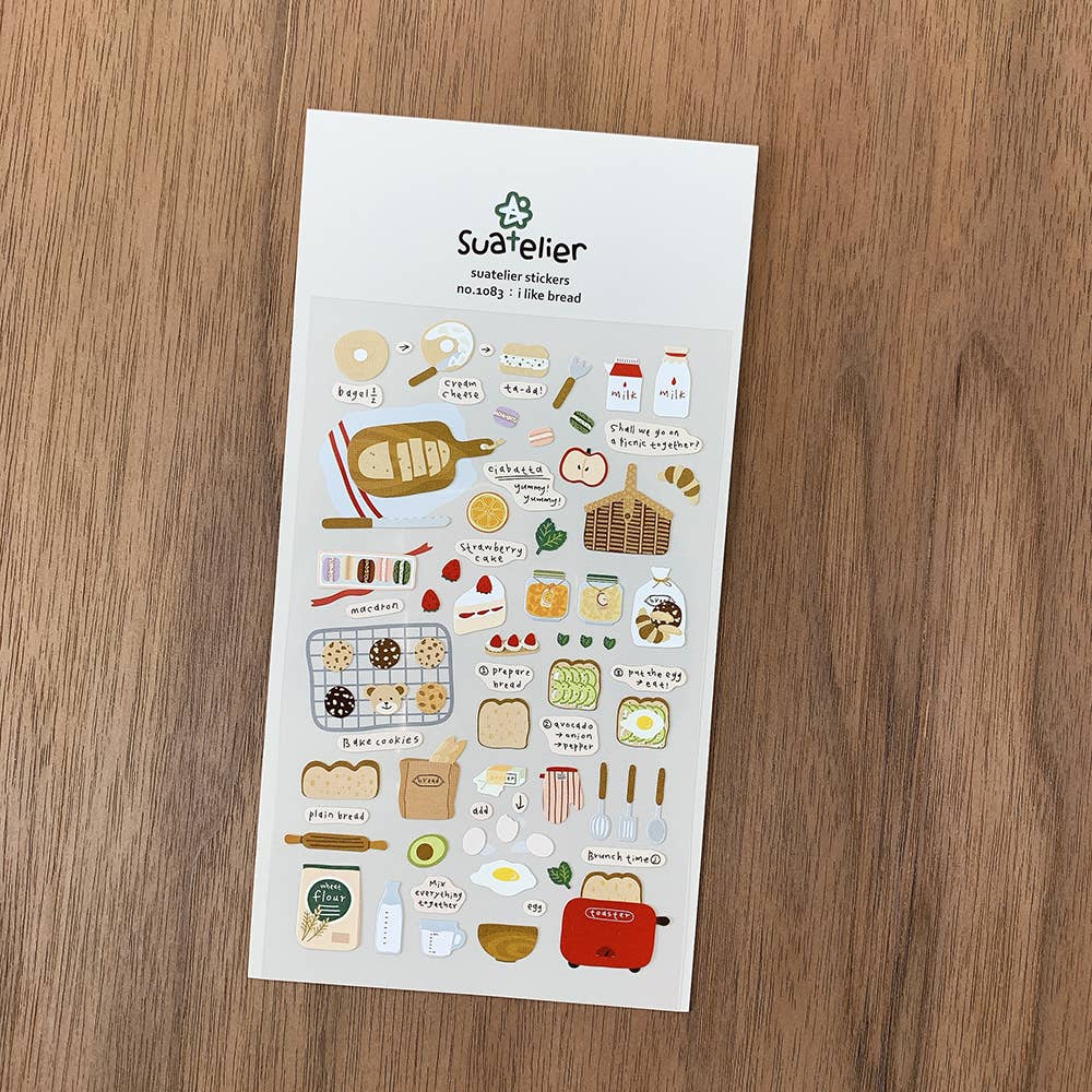 Sheet of Suetteller stickers featuring bread and kitchen items on a wooden surface
