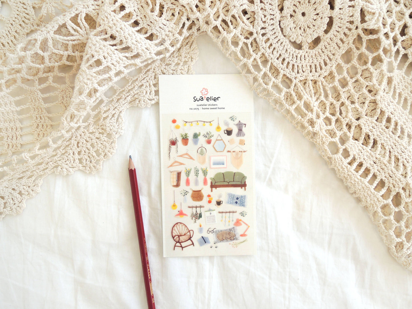 Pack of Suatelier stickers with home illustrations on a textured fabric background