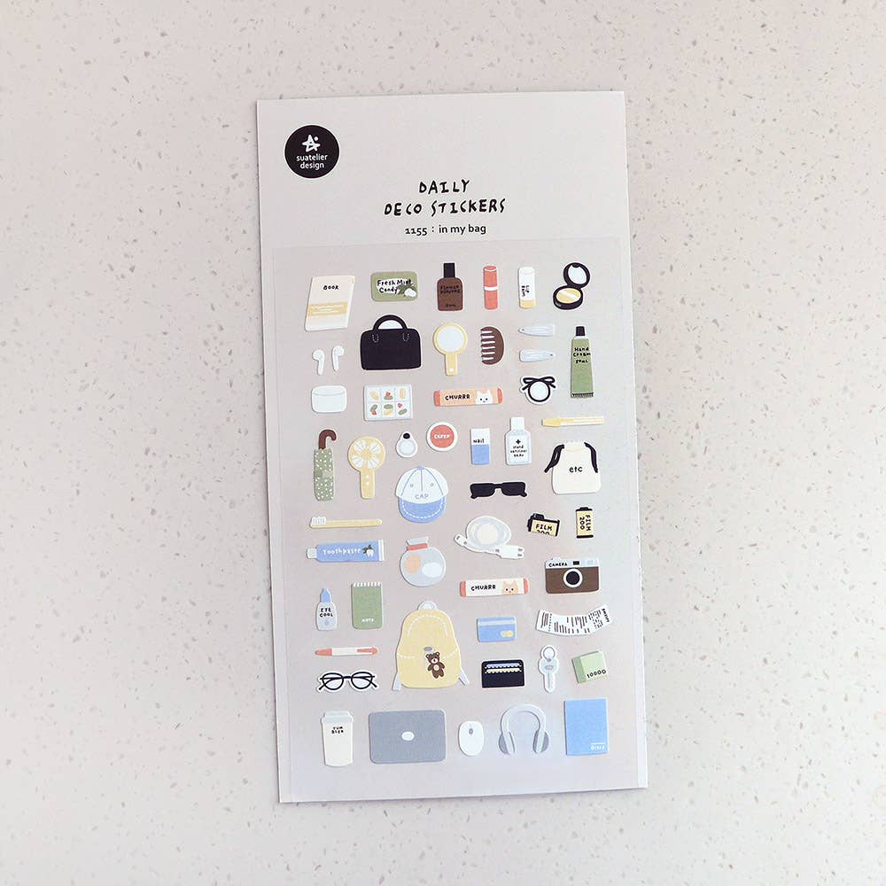 Sheet of decorative Suatelier stickers with various small everyday essentials illustrations on a textured surface