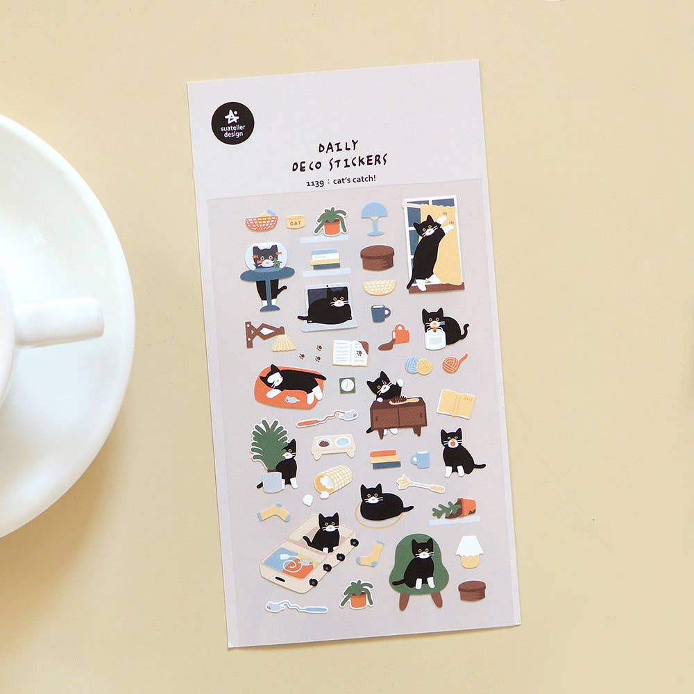 Sheet of cat-themed Suatelier stickers on a beige background