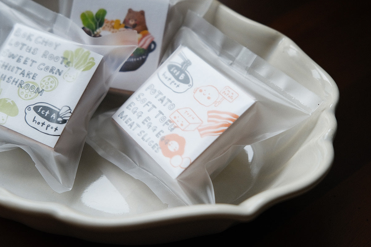 Eileen Tai Hotpot stamps from Set A and Set B in a white ceramic dish