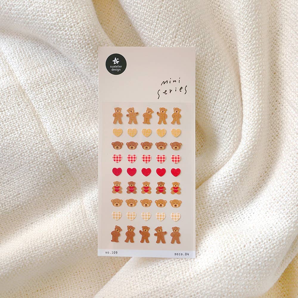 Sheet of decorative stickers with teddy bears and hearts on a textured white background