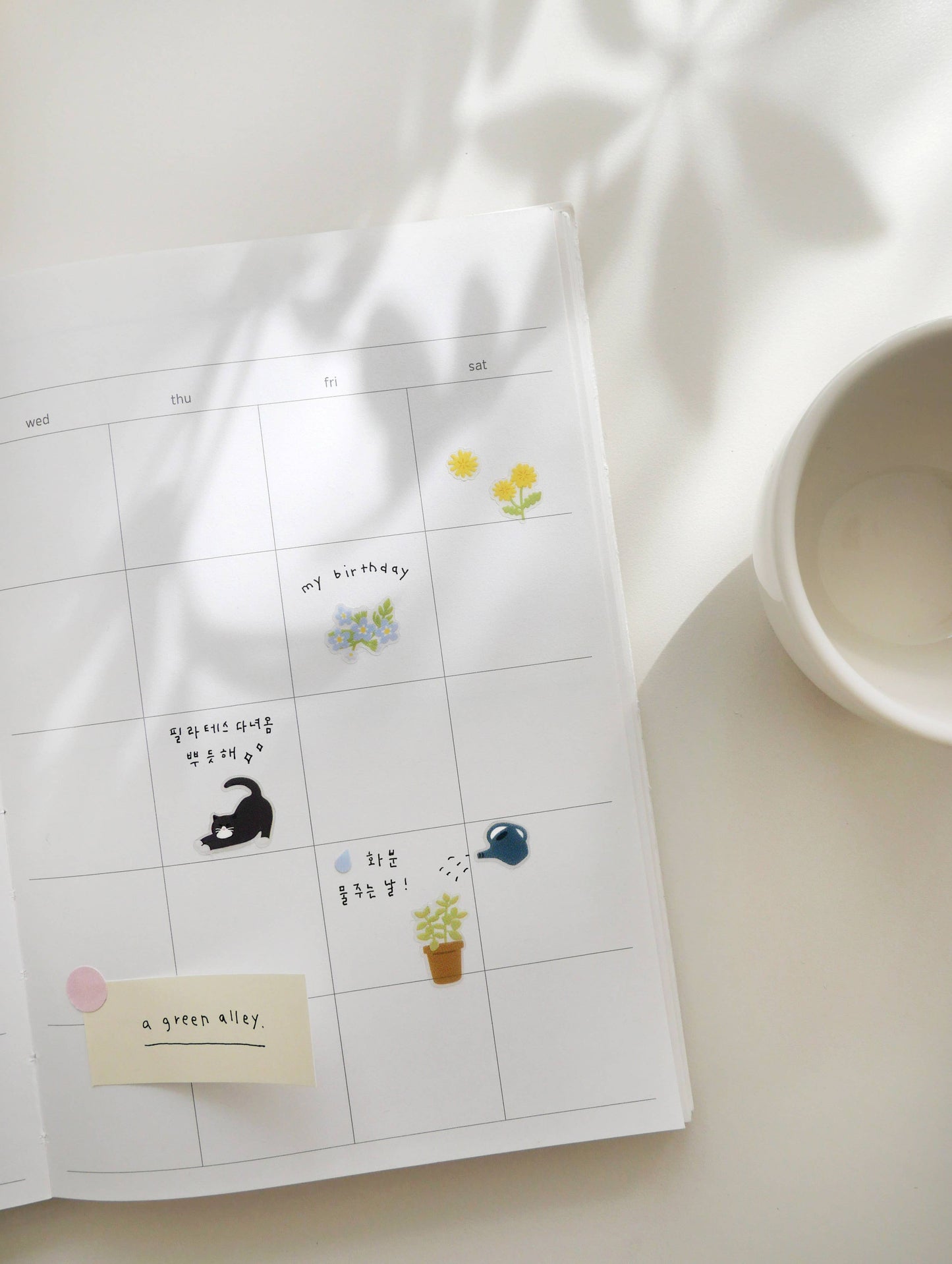 Calendar sheet with Suatelier stickers on a white surface
