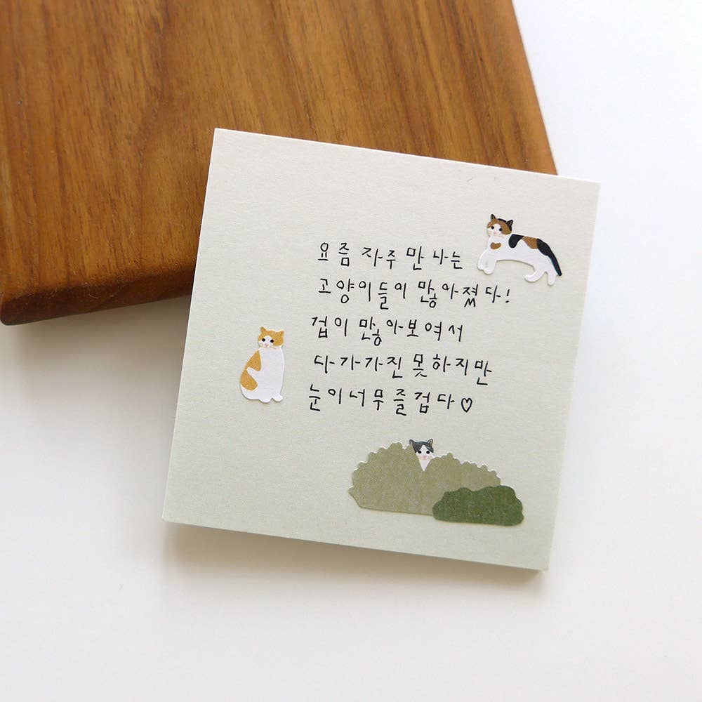 Notebook with cat Suatelier stickers and text on a wooden surface