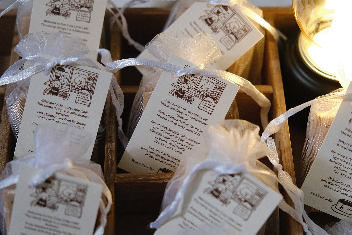 Small wrapped Eileen Tai stamps with tags in a wooden box