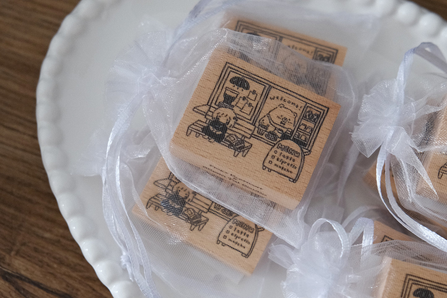Wooden Eileen Tai bear-themed stamps with illustrations and text on a white plate